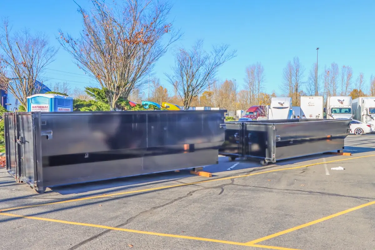 Professional dumpster rental service with roll-off container on residential driveway in East St. Louis